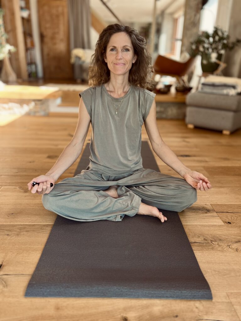 Vanessa assise sur un tapis de yoga au Sanctuaire de Fillinges
